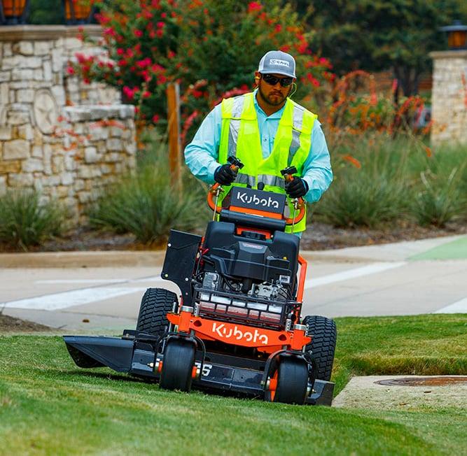 Man mowing lawn with walk-behind mower
