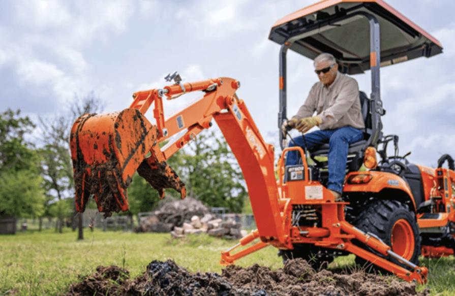 Man using back hoe to dig dirt