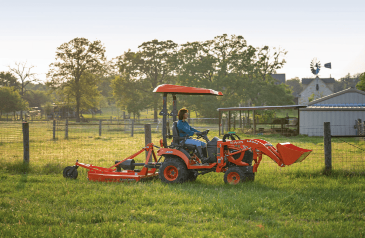Woman mowing lawn with tractor