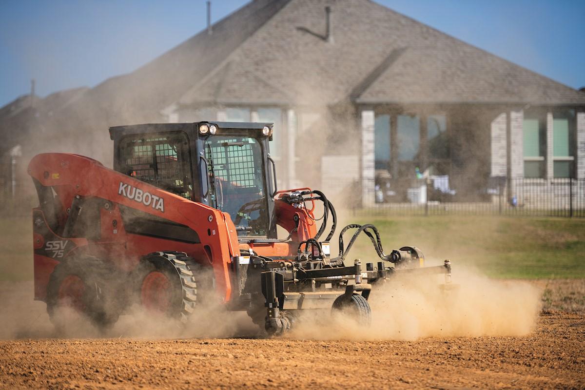 Skid steer leveling out ground on construction site