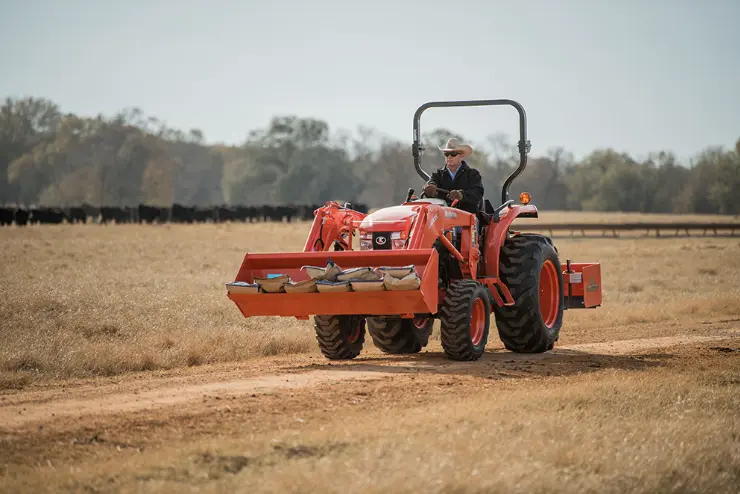 Man moving material in front loader of tractor