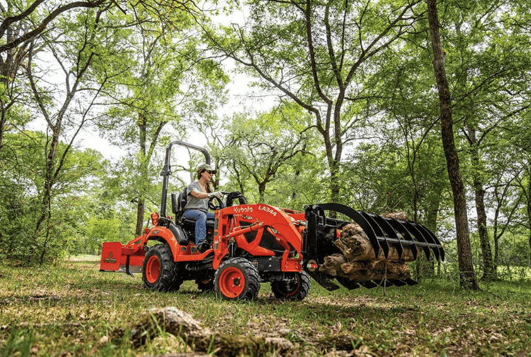 Woman using tractor to move branches