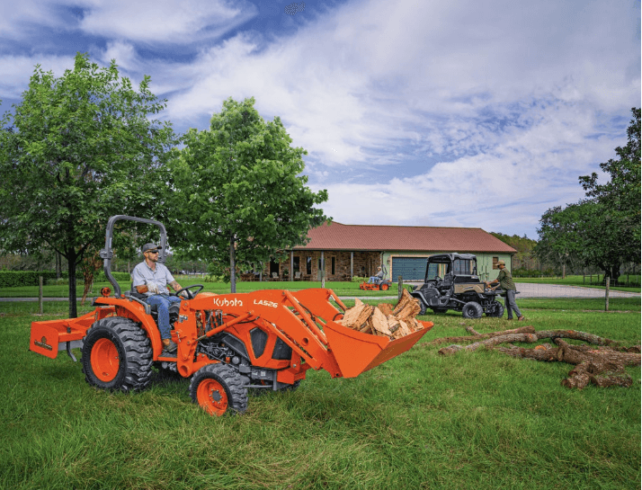 Man moving firewood with front loader attachment