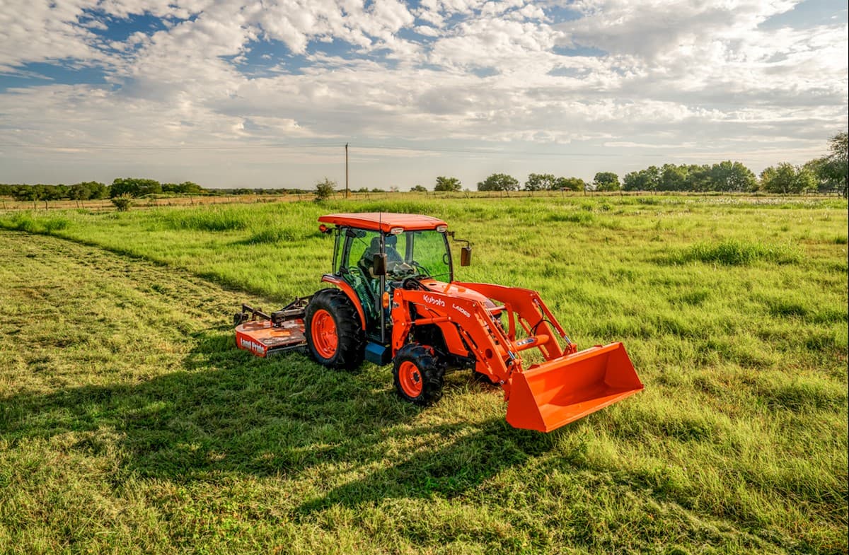 Tractor mowing a field with rear mower