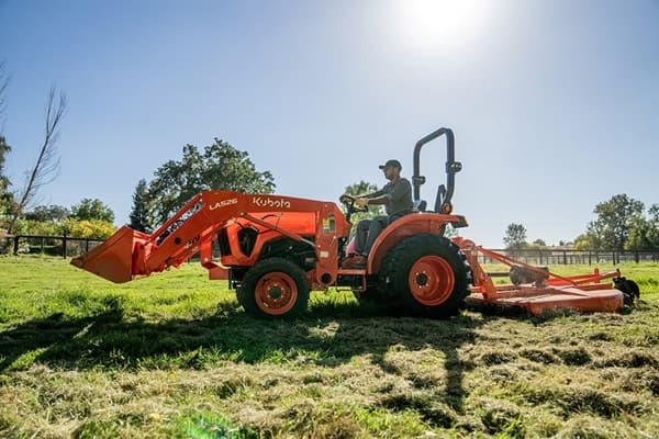 Man mowing lawn with tractor