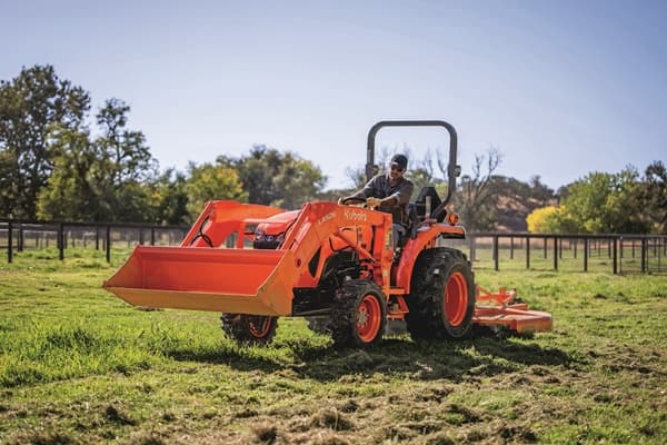 Man mowing lawn with tractor