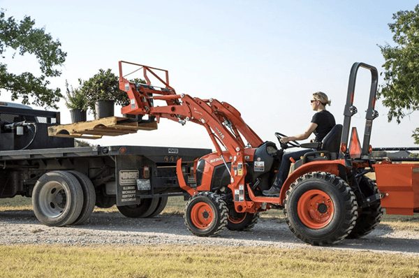 Woman loading pallet of plants onto back of trailer