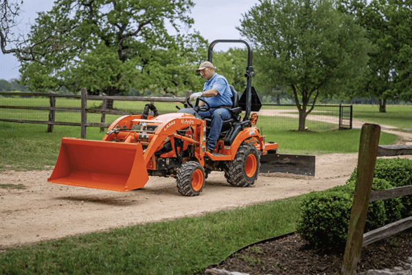 Man grading his driveway with tractor