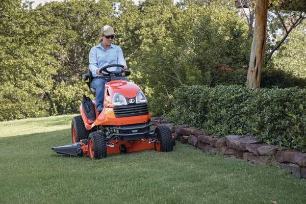 Woman mowing lawn with garden tractor