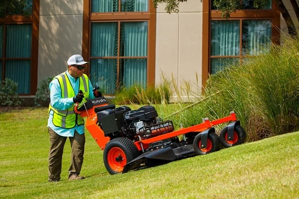 Man pushing a walk-behind mower