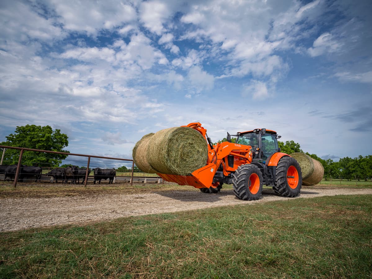 Kubota M7 Tractor carrying two hay bales